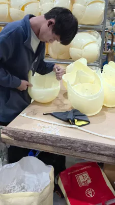 Technician polishing and finishing a motorcycle helmet shell